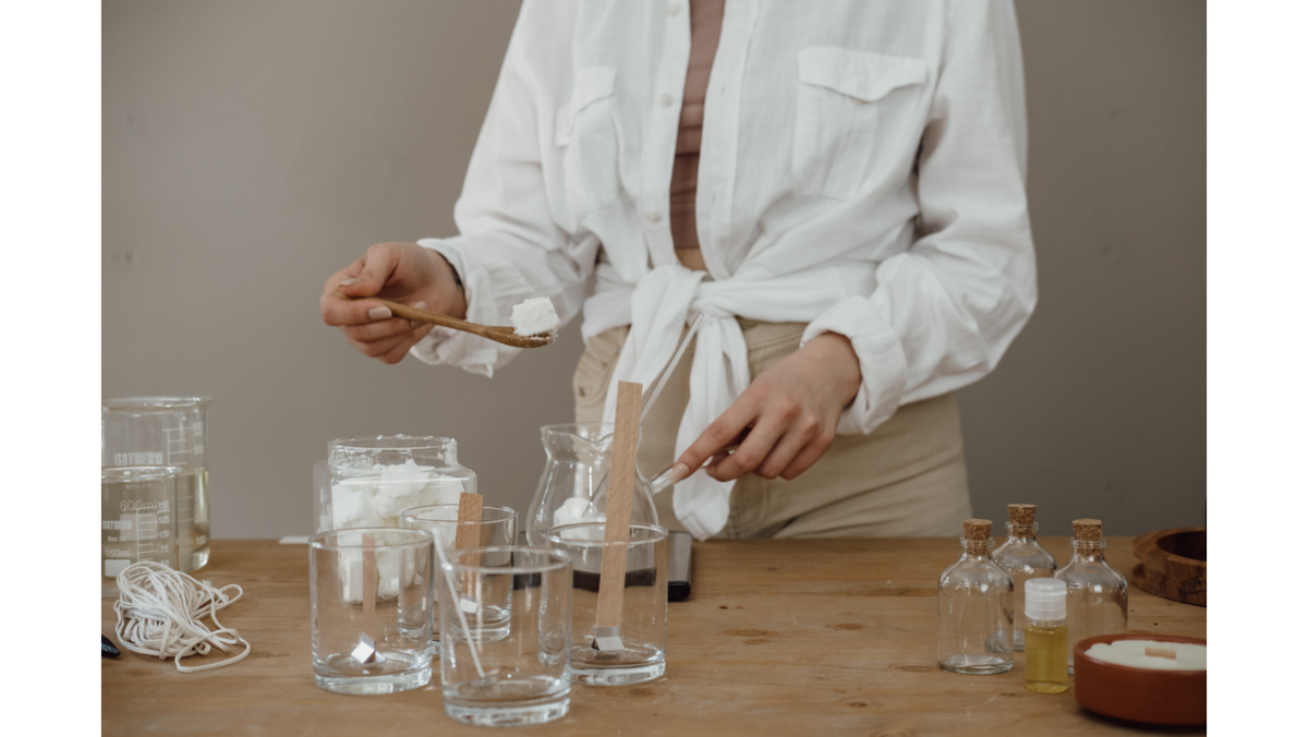 Candle maker weighing soy wax into glass jars